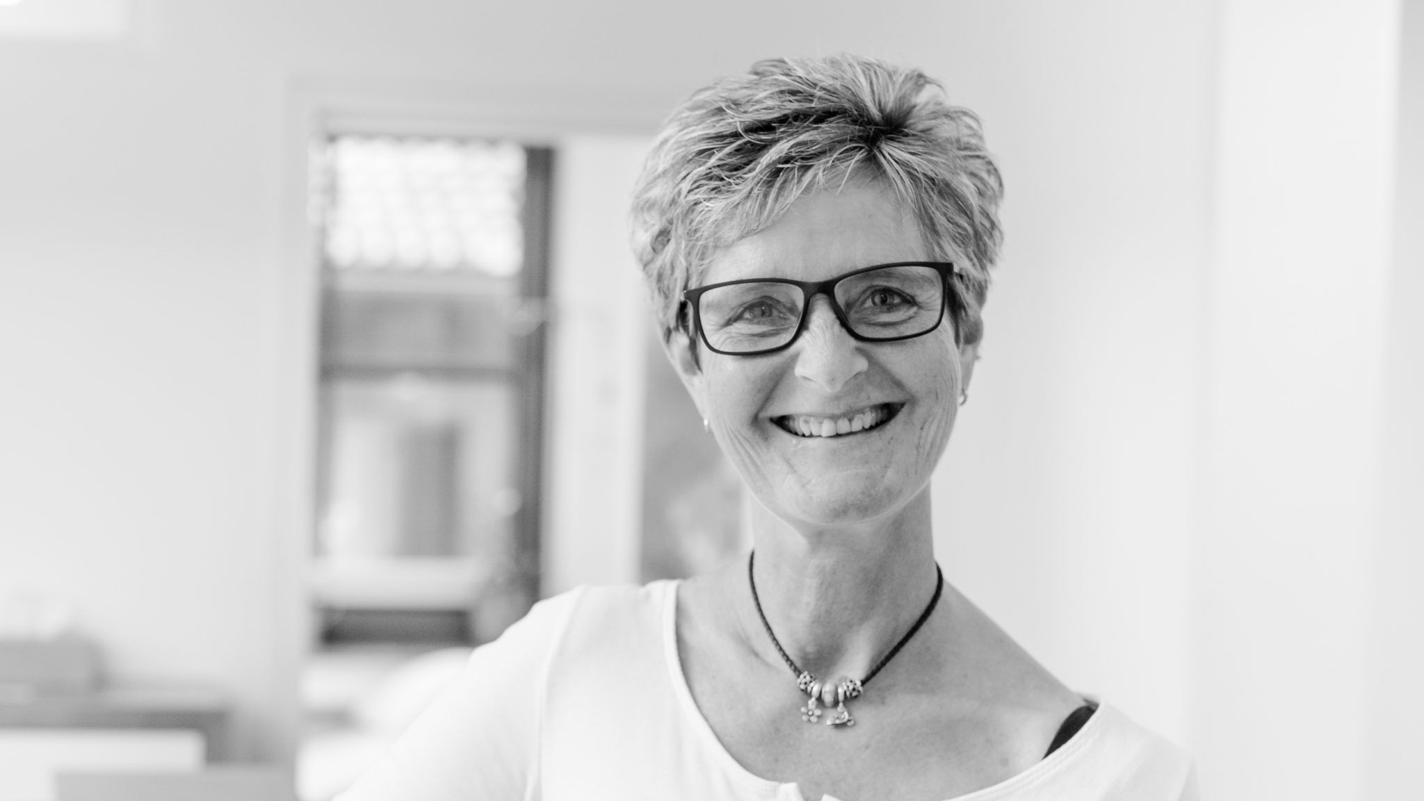 Porträt von Corina Zeuke, MFA in der modernen Hausarztpraxis Keller & Ott in Garmisch-Partenkirchen – freundlich lächelnd in hellem Praxisambiente.