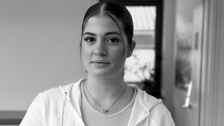 Porträt von Elena Kostadinovik, Auszubildende in der modernen Hausarztpraxis Keller & Ott in Garmisch-Partenkirchen – freundlich lächelnd in hellem Praxisambiente.